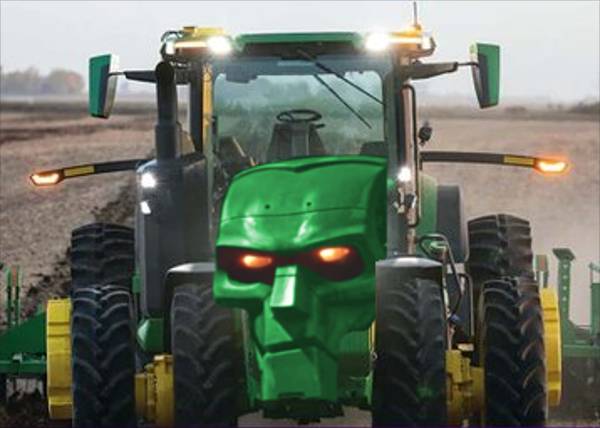 Traktor John Deere z włączonymi światłami, zwrócony przodem do zdjęcia. Zamiast jego przedniej części nałożono głowę robota o groźnym wyrazie twarzy. Jego twarz ma taką samą zieloną barwę jak lakier traktora, a oczy są pomarańczowe jak jego światła